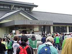 まごころネットの活動拠点となっている遠野市総合福祉センター。朝8時の朝礼に集まってくるボランティア（約200人）。活動内容と分担を確認しバスで支援先へ。