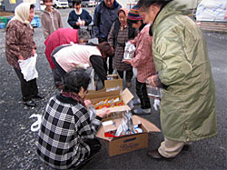 牡鹿エリア仮設住宅での、年末物資提供のようす。皆で分け合う、生協の班共同購入と同じ風景です。